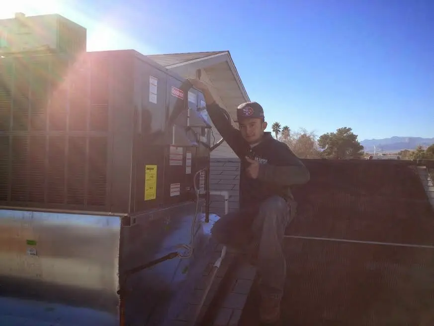 HVAC technician performing Air Duct Cleaning on a rooftop unit in Jeffersonville