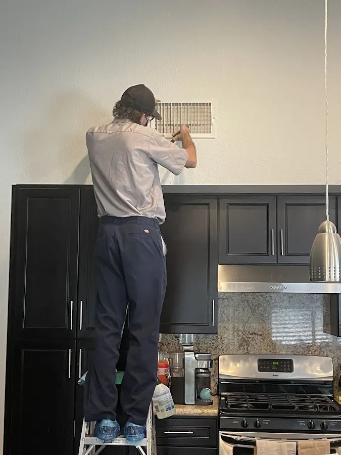 Technician inspecting an air vent during HVAC service in Jeffersonville